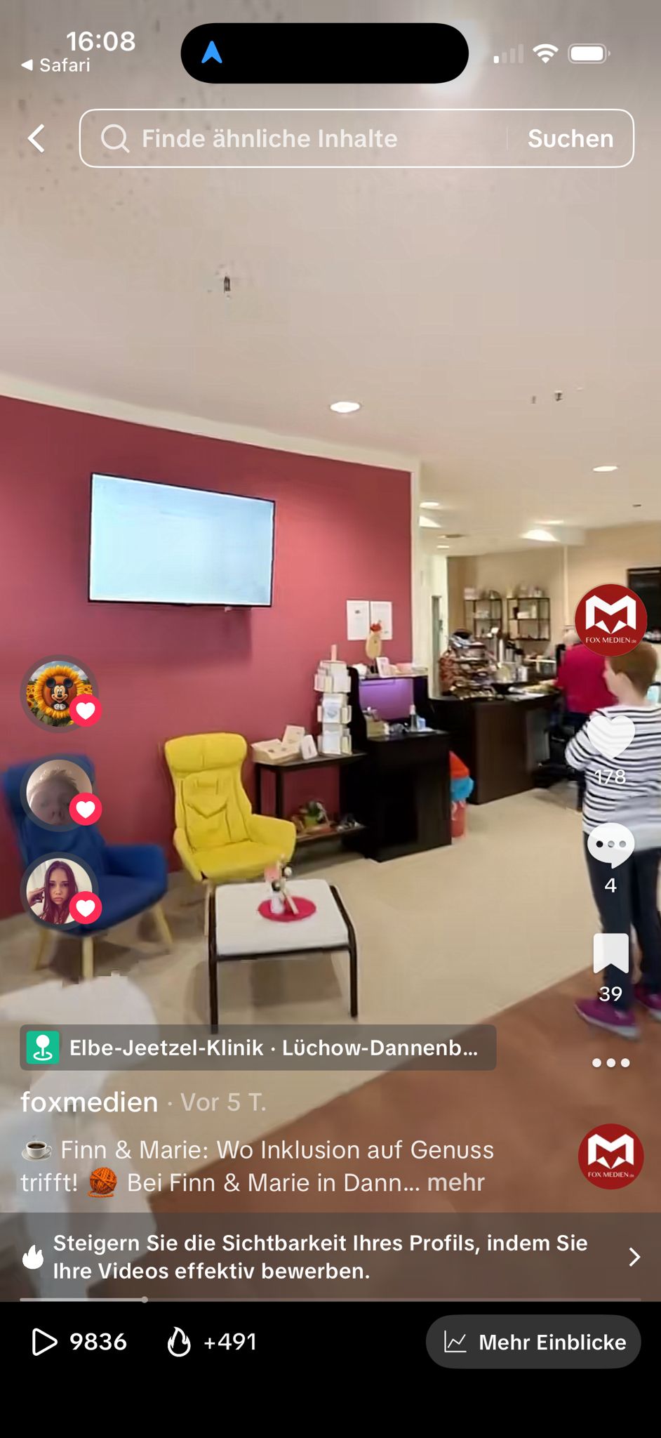 Gemütliche Innenansicht des Inklusionscafés Finn & Marie mit bunten Sesseln und digitalem Werbebildschirm von Fox Medien.